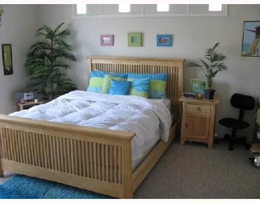 a bedroom with a bed table and a potted plant