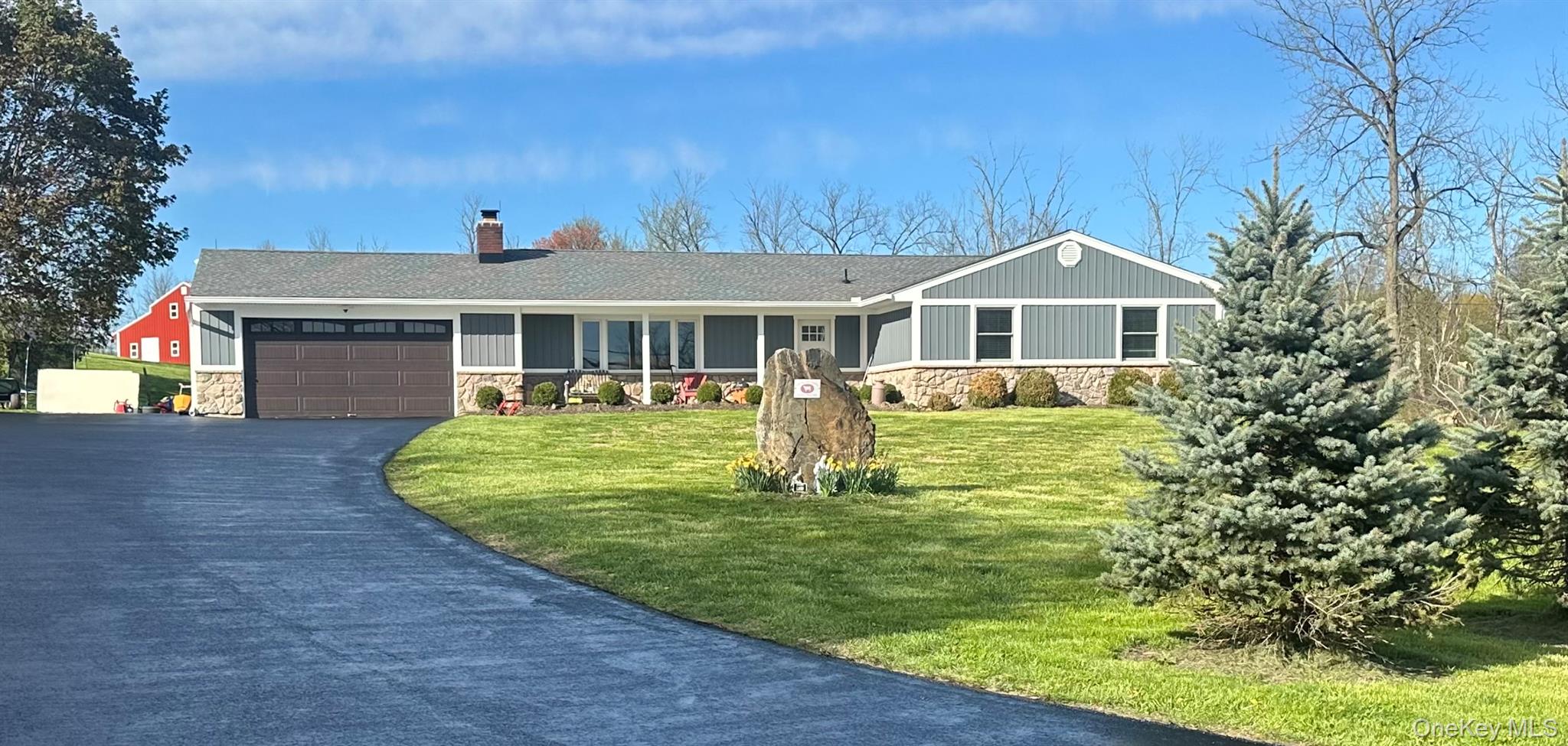 Ranch-style residence featuring a royal composite gray -blue siding exterior with stone accents