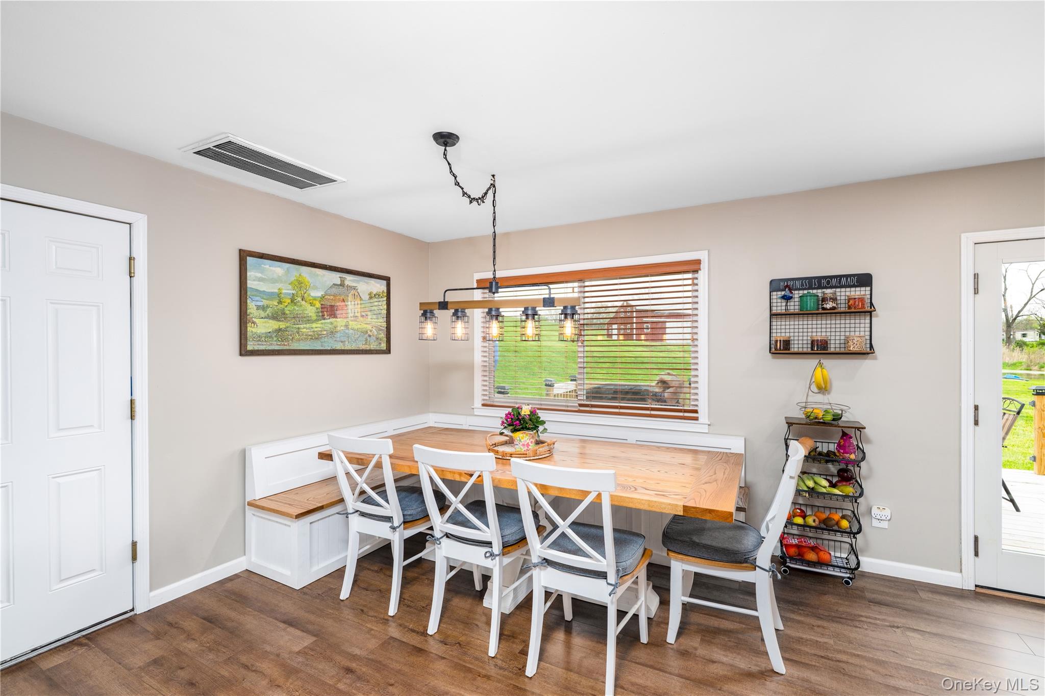 41 Diddell Road Wappingers Falls, NY 12590 - Photo 13 of 44 Custom built-in Dining area featuring wood flooring, a built-in bench with storage, a large window with wooden blinds, and a multi-light fixture with industrial-style caging