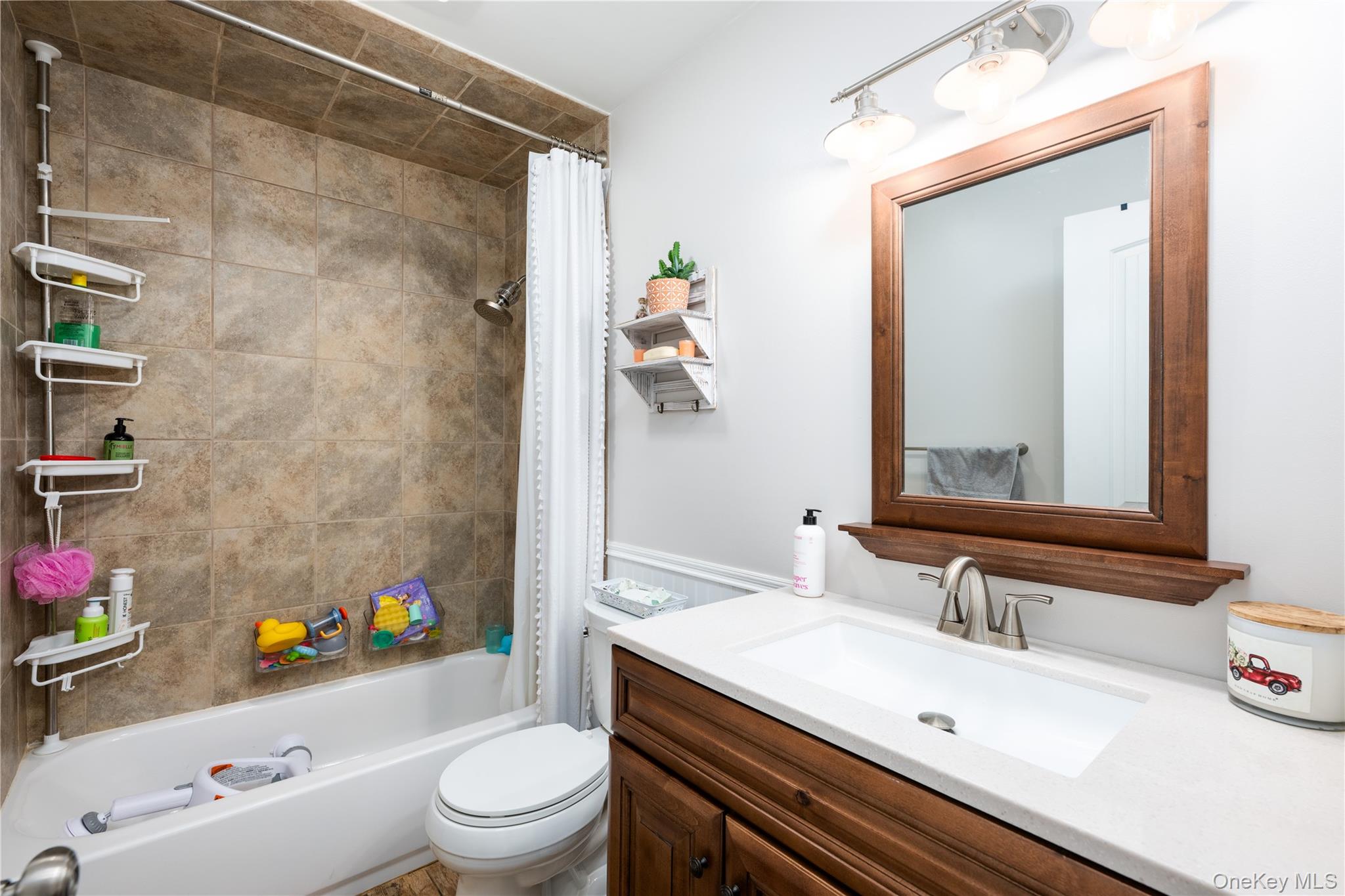 41 Diddell Road Wappingers Falls, NY 12590 - Photo 21 of 44 Hall Bathroom featuring a single Quartz vanity, a wood-framed mirror, and brushed nickel hardware