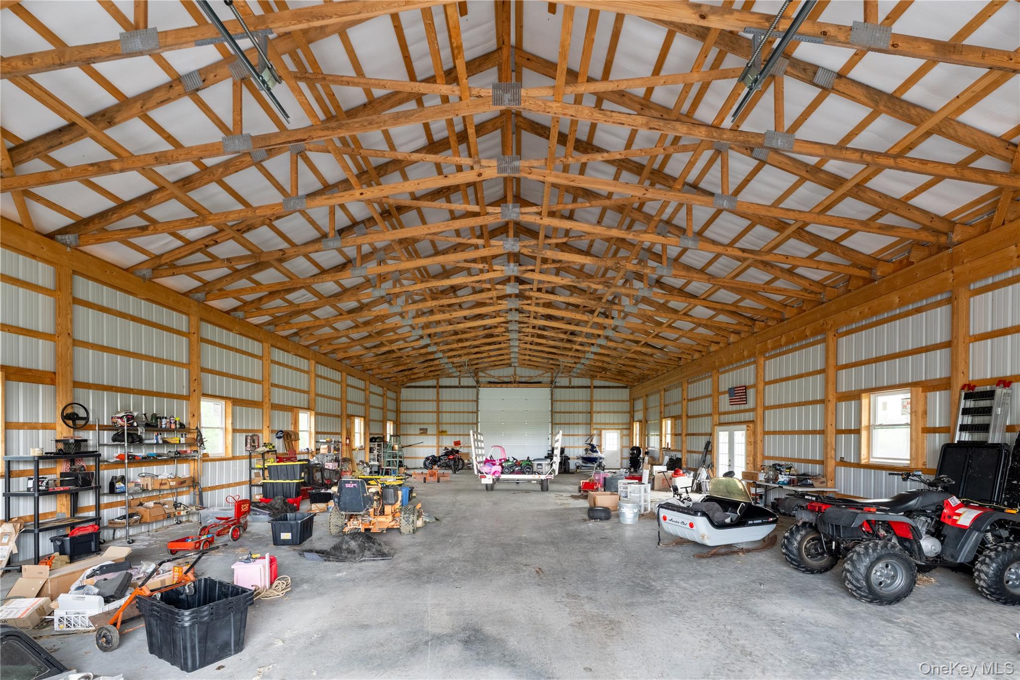 41 Diddell Road Wappingers Falls, NY 12590 - Photo 40 of 44 Expansive 3,200 sq ft utility barn featuring exposed wood trusses, concrete flooring, multiple windows, and a roll-up door