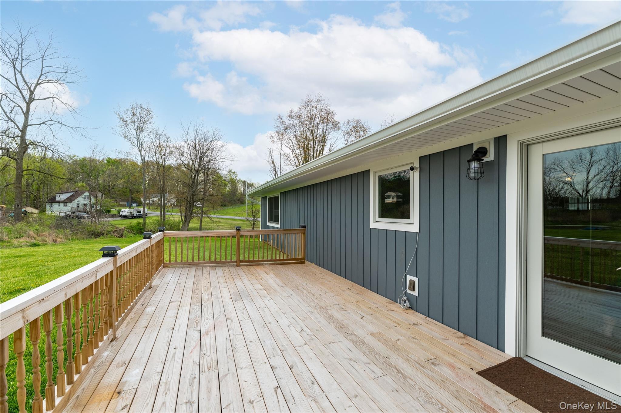 41 Diddell Road Wappingers Falls, NY 12590 - Photo 5 of 44 Expansive wood deck with a natural finish, featuring a wood railing with balusters, and a glass-paneled door for outdoor access
