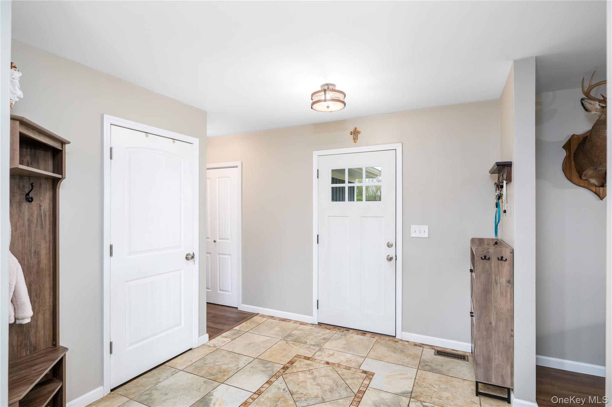 41 Diddell Road Wappingers Falls, NY 12590 - Photo 8 of 44 Entry foyer featuring ceramic tile flooring with decorative inlay, a white paneled door, and a white exterior door with window panes