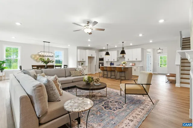 a living room with furniture a rug a large window and a fireplace