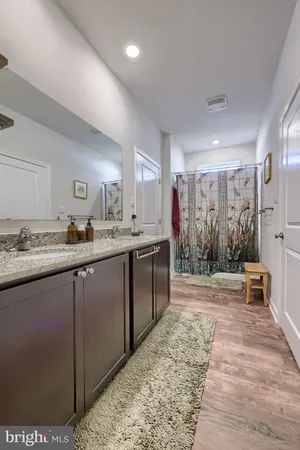 a spacious bathroom with a sink a mirror and a shower