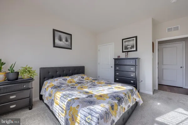 a bedroom with a bed and a potted plant