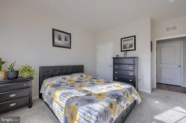 a bedroom with a bed and a potted plant