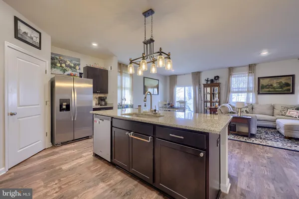a kitchen with granite countertop a sink cabinets and stainless steel appliances