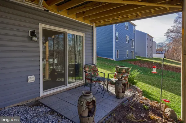 a view of a chair and table in backyard of the house