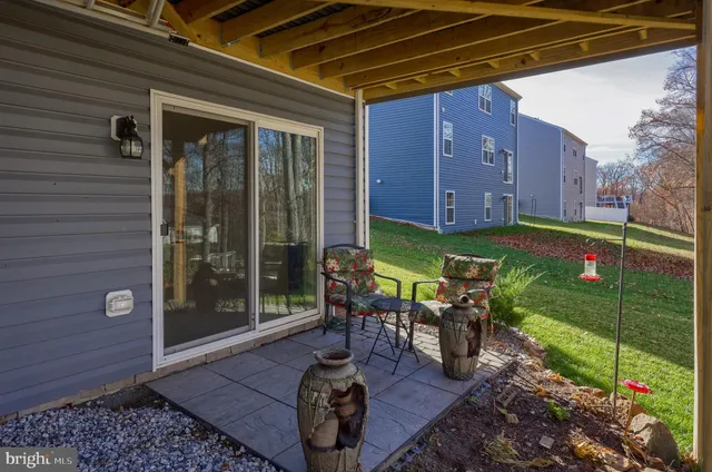 a view of a chair and table in backyard of the house