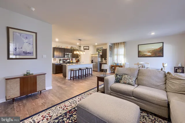 a living room with furniture a rug and kitchen view