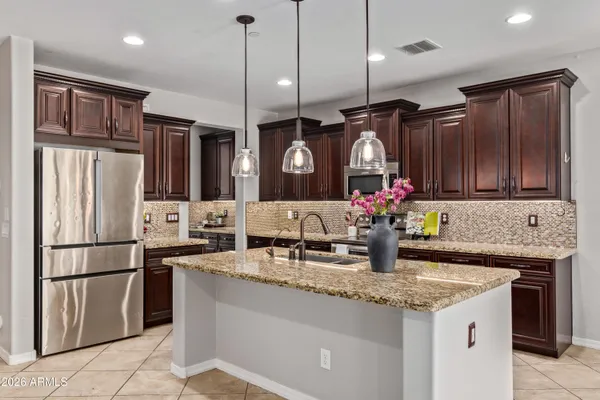 a kitchen with stainless steel appliances granite countertop a sink stove and cabinets