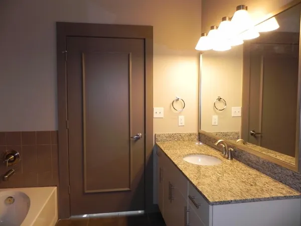 a bathroom with a granite countertop sink and a mirror