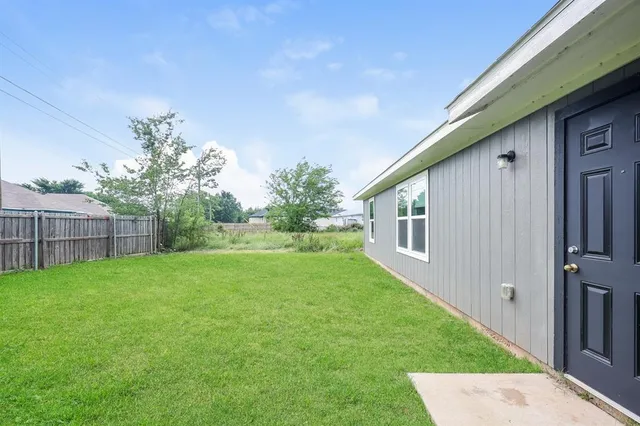 a view of backyard of house with green space