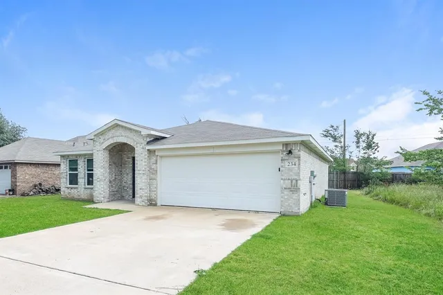 a front view of a house with a garden and yard
