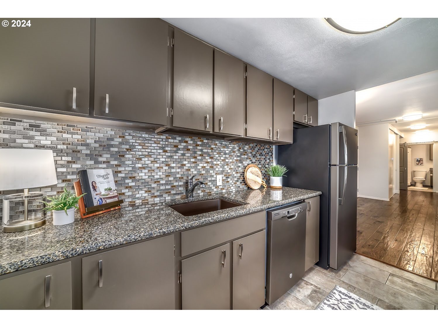 1313 Lincoln Street Eugene, OR 97401 - Photo 12 of 24 a kitchen with granite countertop stainless steel appliances a sink a refrigerator a counter and cabinets