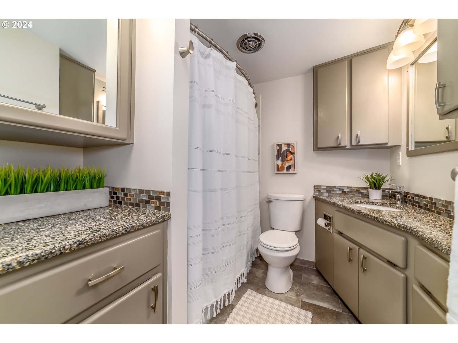 1313 Lincoln Street Eugene, OR 97401 - Photo 18 of 24 a bathroom with a granite countertop sink a toilet a mirror and bathtub