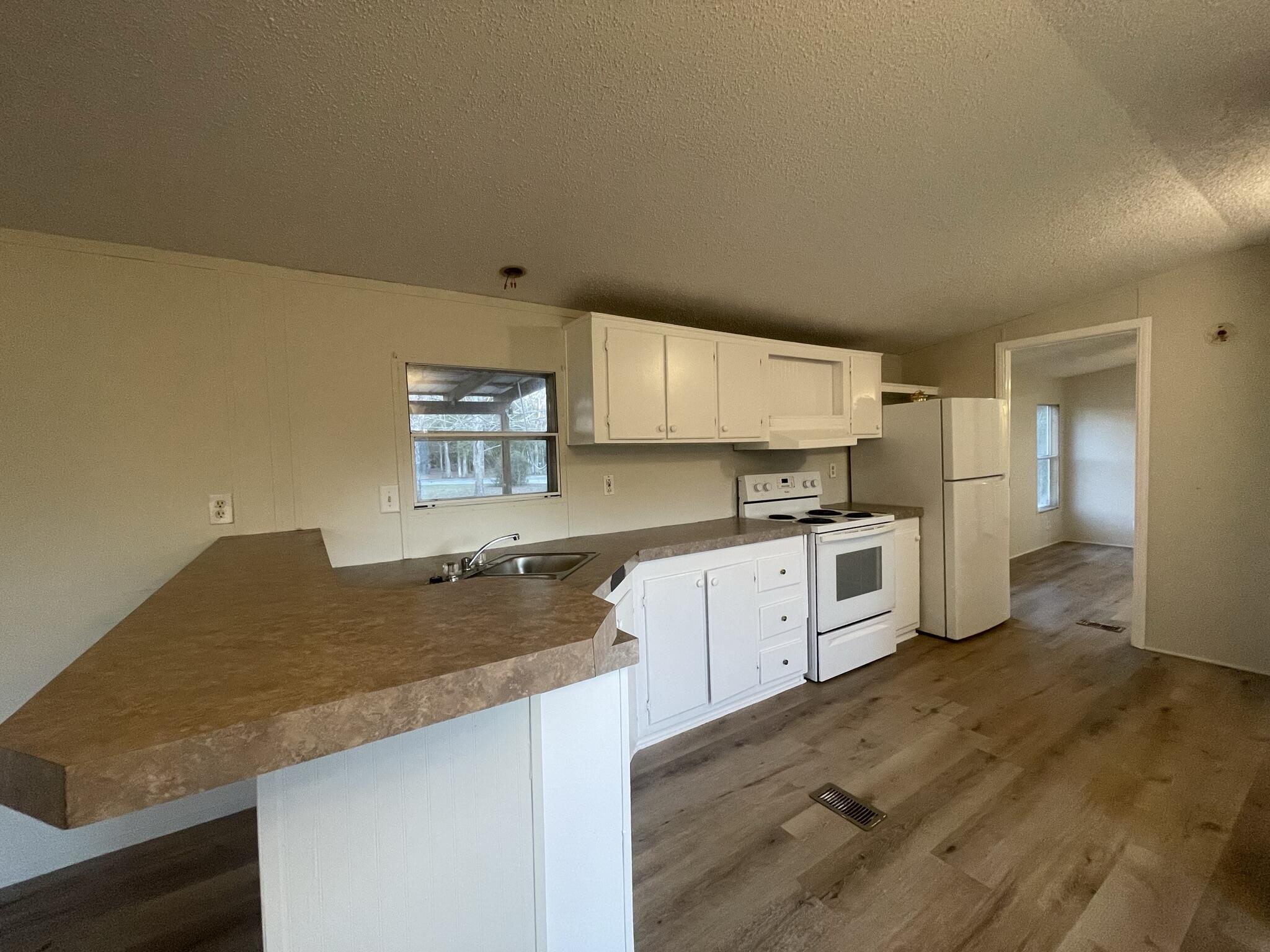 5472 Elzie Road Baker, FL 32531 - Photo 9 of 16 a kitchen with granite countertop a sink and cabinets