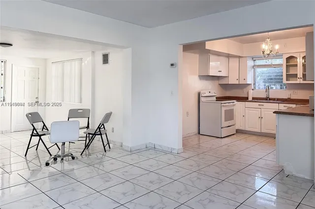 a view of kitchen with cabinets table and chairs