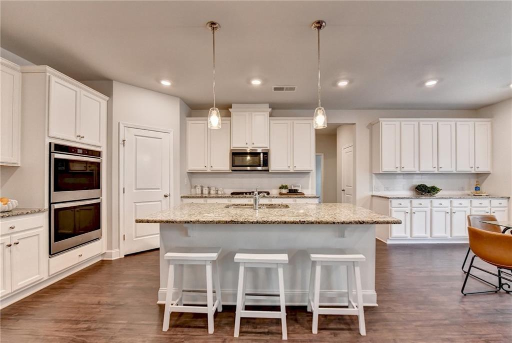 2017 Yvette Way Braselton, GA 30517 - Photo 14 of 75 a large kitchen with granite countertop lots of counter space and stainless steel appliances