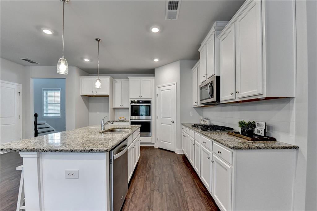 2017 Yvette Way Braselton, GA 30517 - Photo 16 of 75 a kitchen with stainless steel appliances granite countertop wooden cabinets and a sink