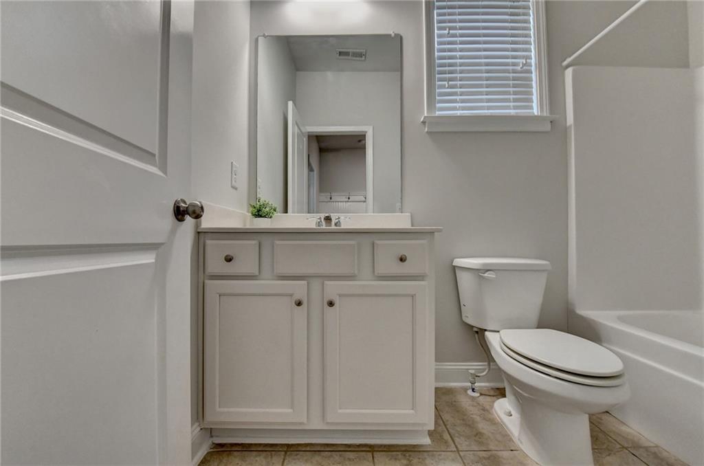 2017 Yvette Way Braselton, GA 30517 - Photo 37 of 75 a bathroom with a toilet a sink and mirror
