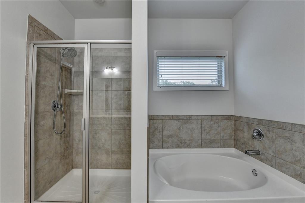 2017 Yvette Way Braselton, GA 30517 - Photo 53 of 75 a bathroom with a bathtub and a shower