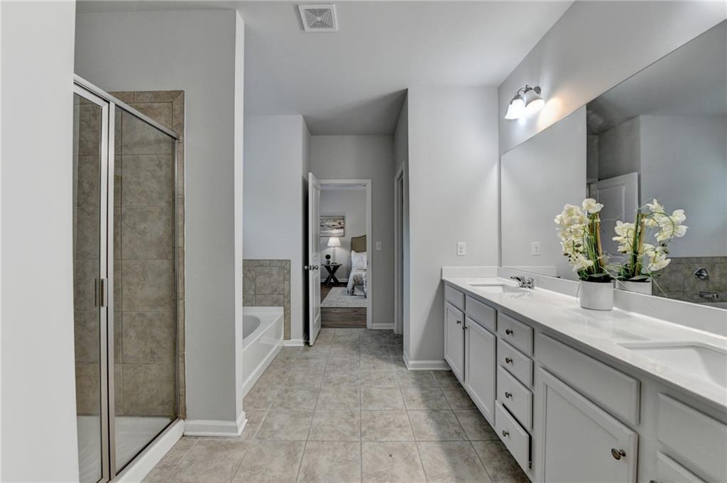 2017 Yvette Way Braselton, GA 30517 - Photo 55 of 75 a spacious bathroom with a granite countertop sink and a mirror