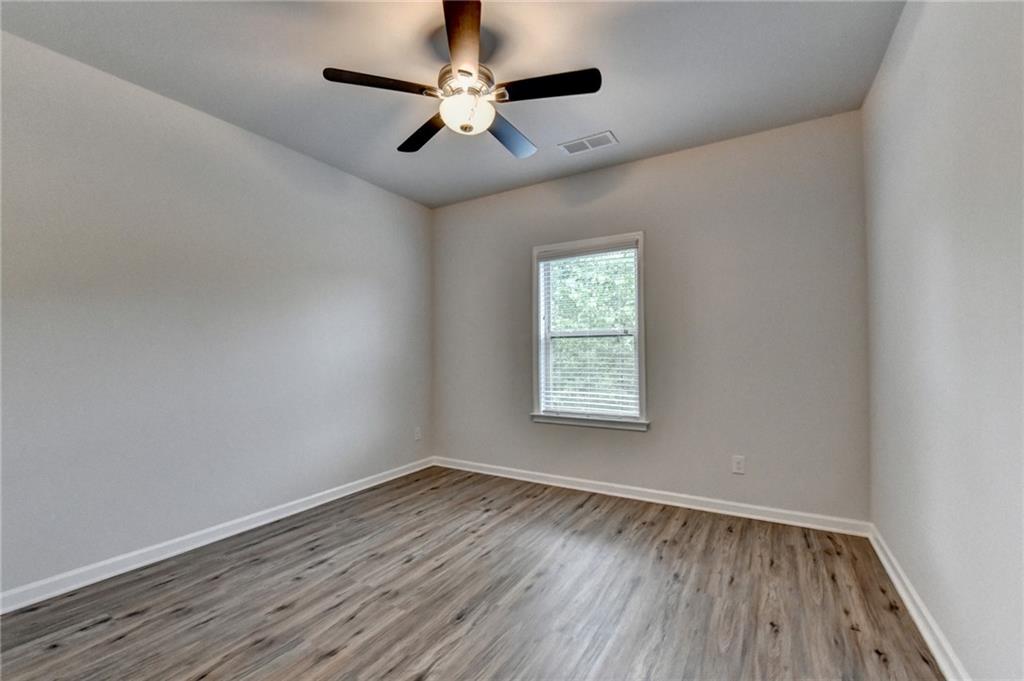 2017 Yvette Way Braselton, GA 30517 - Photo 62 of 75 an empty room with wooden floor ceiling fan and window