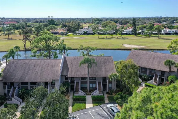 an aerial view of a house with a garden and lake view