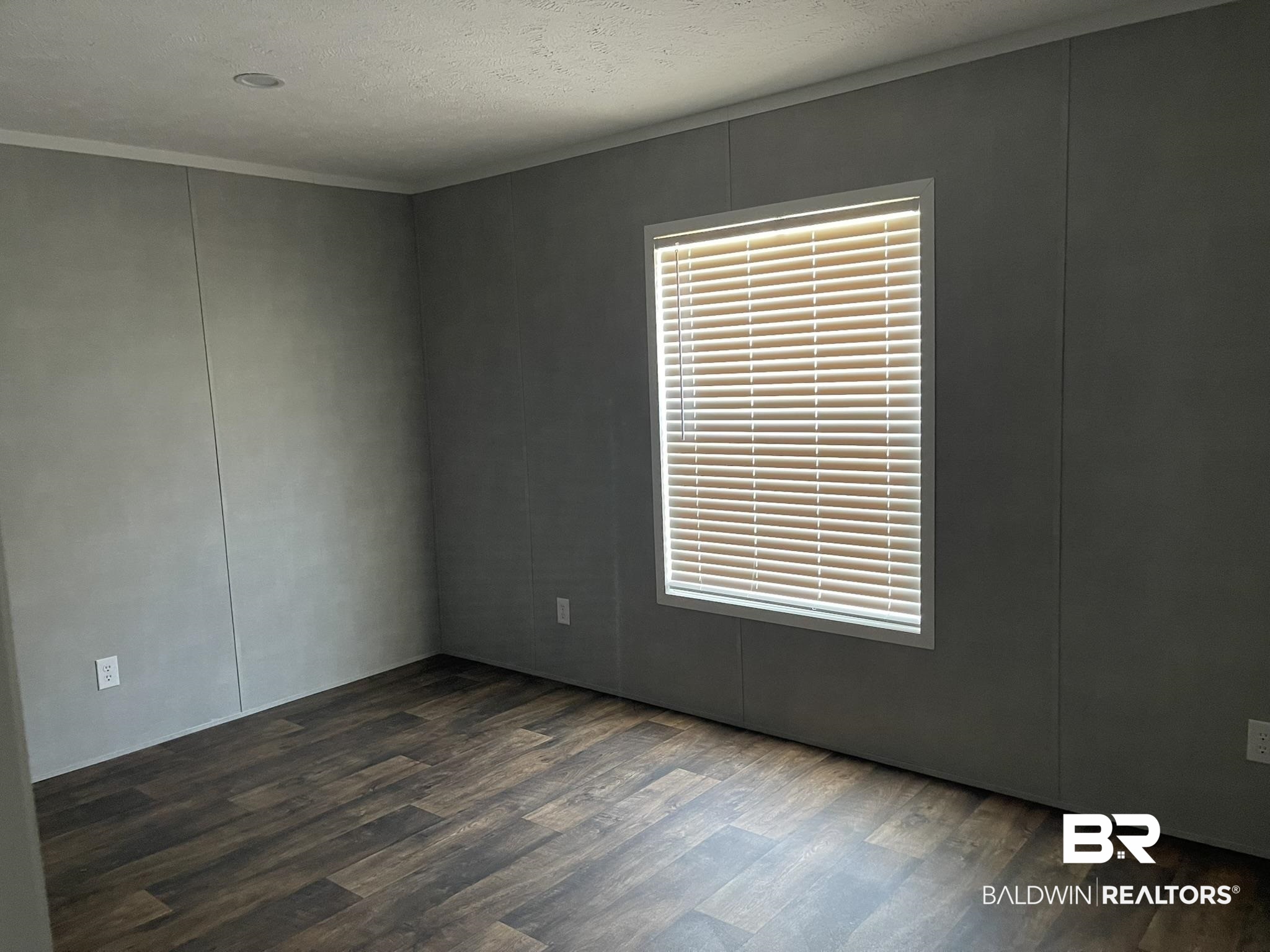 9202 Bay Pnes Road Elberta, AL 36530 - Photo 10 of 17 Unfurnished room with dark wood-style flooring, a textured ceiling, a decorative wall, and crown molding