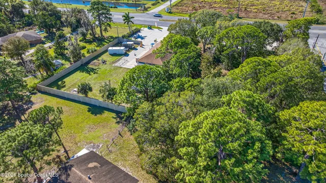 an aerial view of residential houses with outdoor space and trees