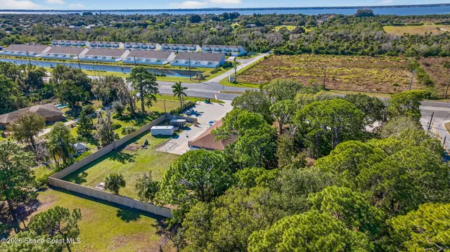 an aerial view of residential houses with outdoor space and trees