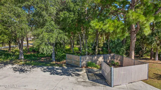 a view of a swimming pool with lawn chairs under an umbrella