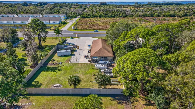 an aerial view of a house with a garden and lake view