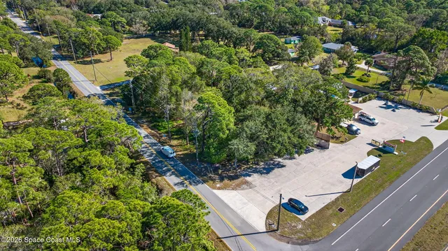 an aerial view of a house with a yard and lake view