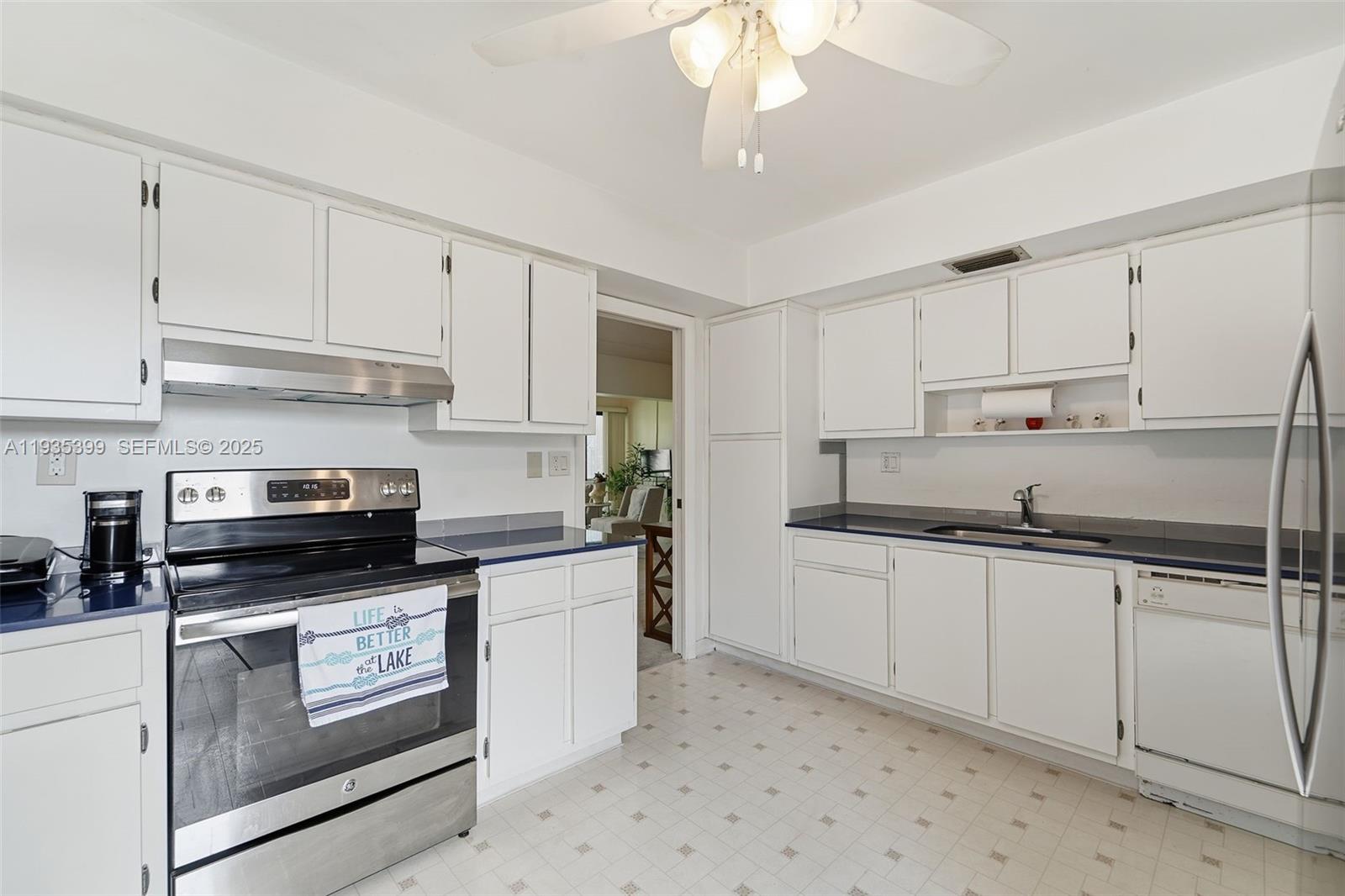 6561 Spring Bottom Way, Unit 234 Boca Raton, FL 33433 - Photo 11 of 31 a kitchen with granite countertop a sink stainless steel appliances and white cabinets