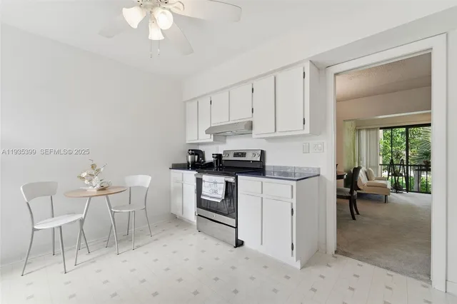a kitchen with a white cabinets and chairs