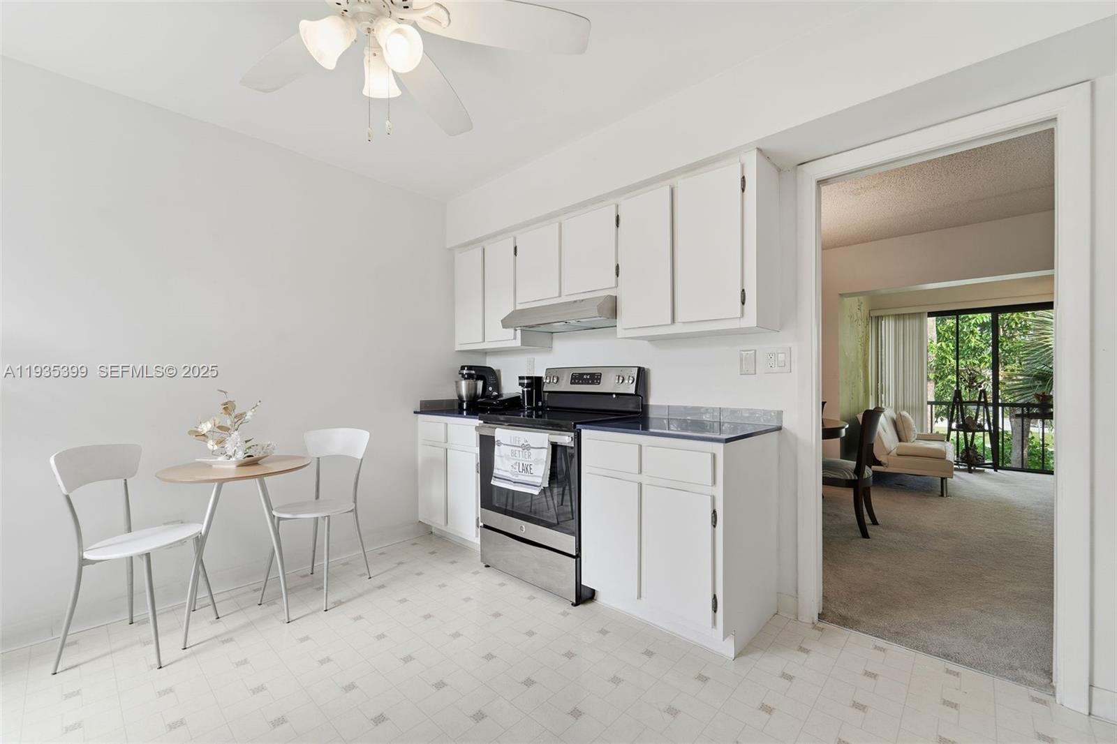 6561 Spring Bottom Way, Unit 234 Boca Raton, FL 33433 - Photo 13 of 31 a kitchen with a white cabinets and chairs