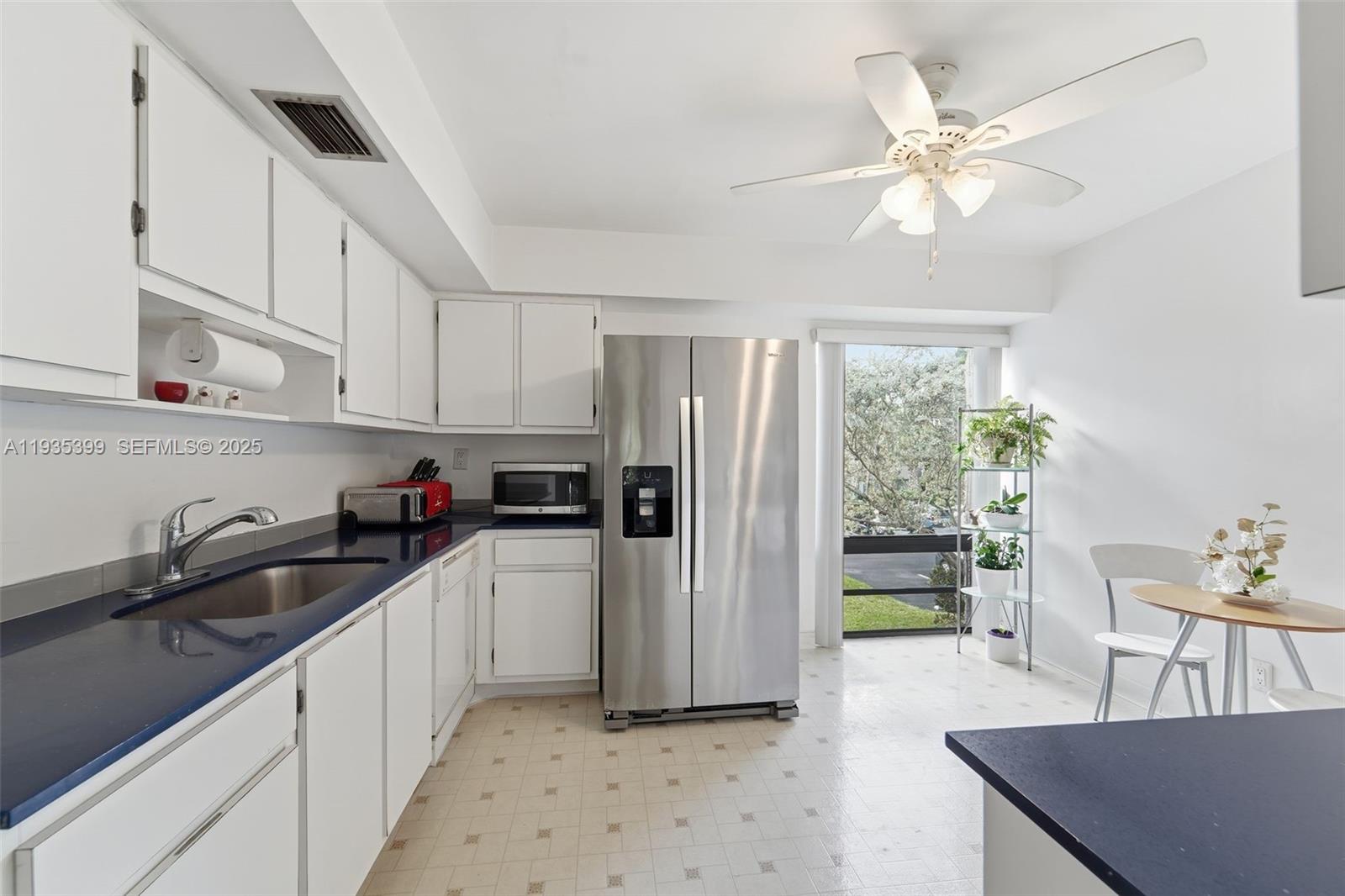 6561 Spring Bottom Way, Unit 234 Boca Raton, FL 33433 - Photo 15 of 31 a kitchen with a sink a refrigerator and cabinets