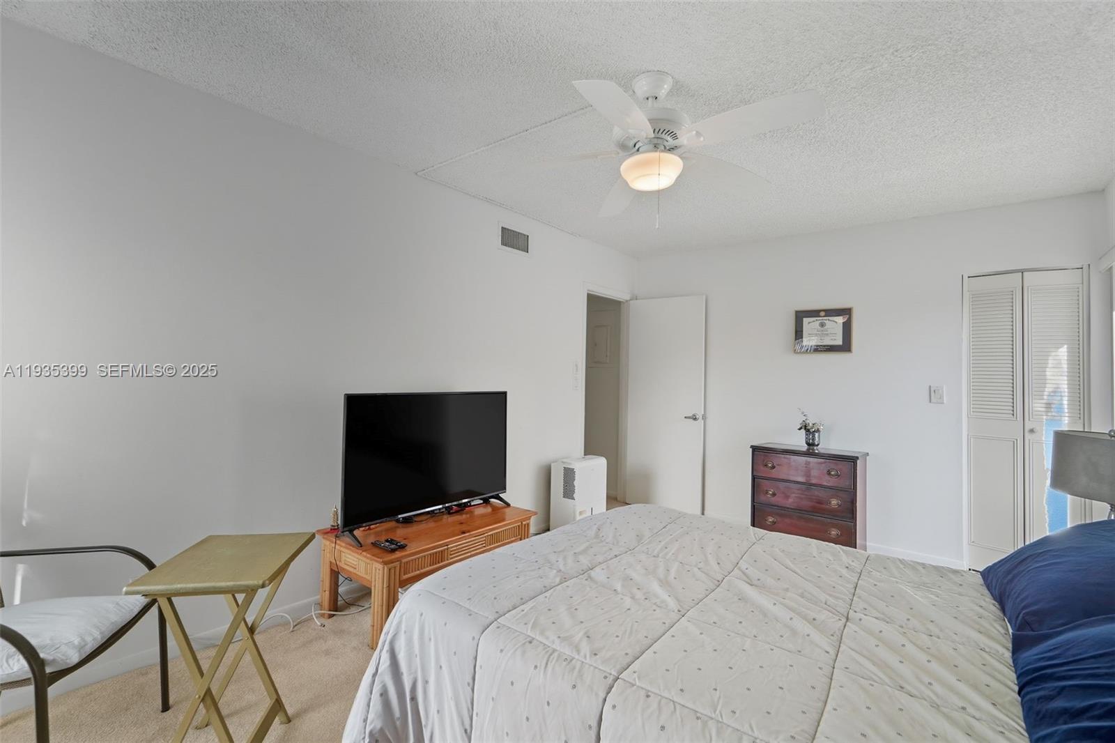 6561 Spring Bottom Way, Unit 234 Boca Raton, FL 33433 - Photo 19 of 31 a bedroom with a bed and a flat screen tv