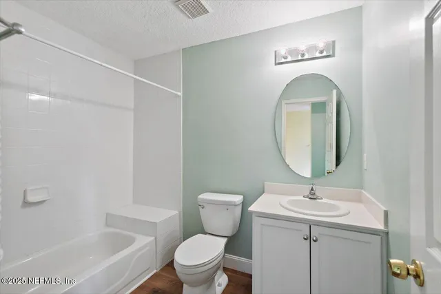 a bathroom with a toilet a sink a mirror and a bathtub