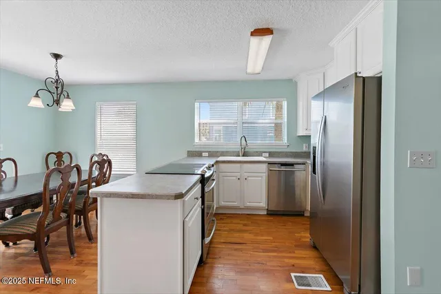 a kitchen with kitchen island a sink stove and refrigerator