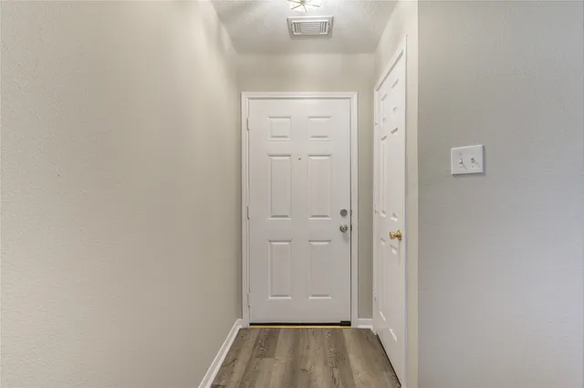 a view of a hallway with wooden floor