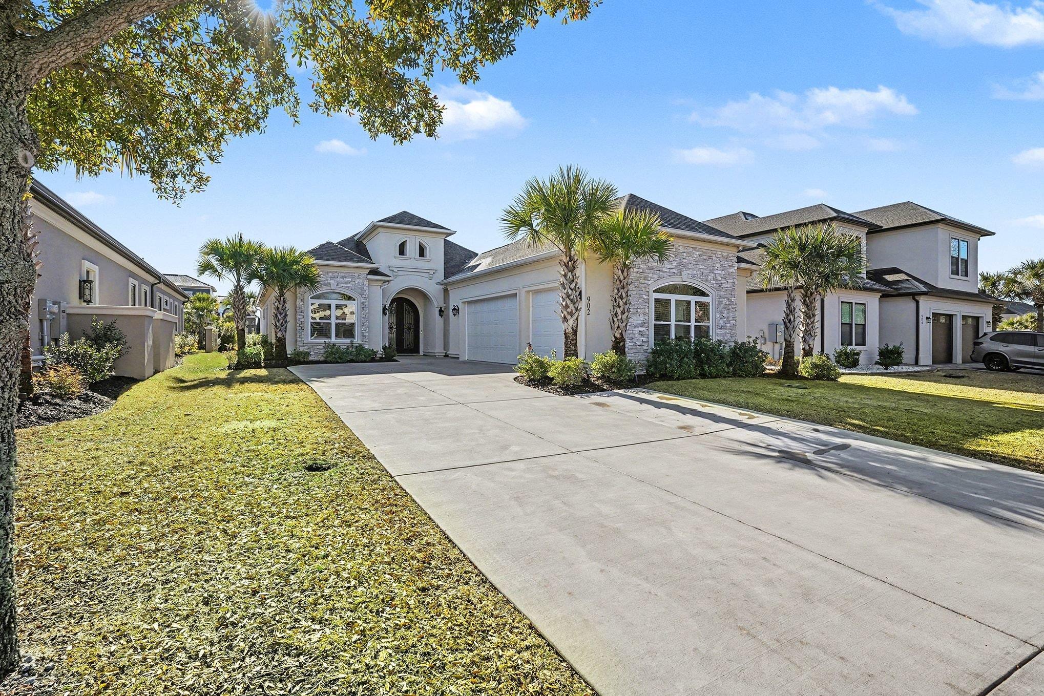 902 Shipmaster Avenue Myrtle Beach, SC 29579 - Photo 1 of 40 View of front of home with stone siding, concrete driveway, a front yard, and stucco siding