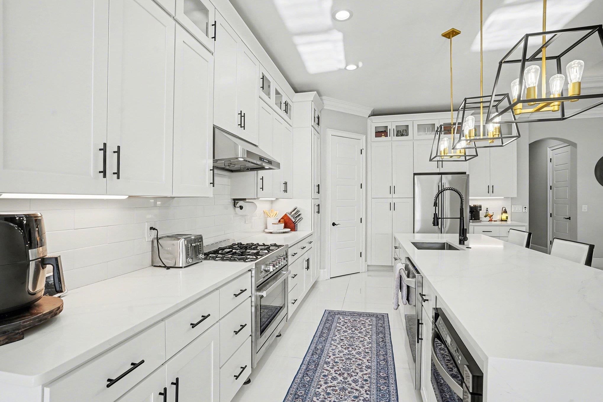 902 Shipmaster Avenue Myrtle Beach, SC 29579 - Photo 10 of 40 Kitchen with glass insert cabinets, arched walkways, pendant lighting, white cabinetry, and appliances with stainless steel finishes