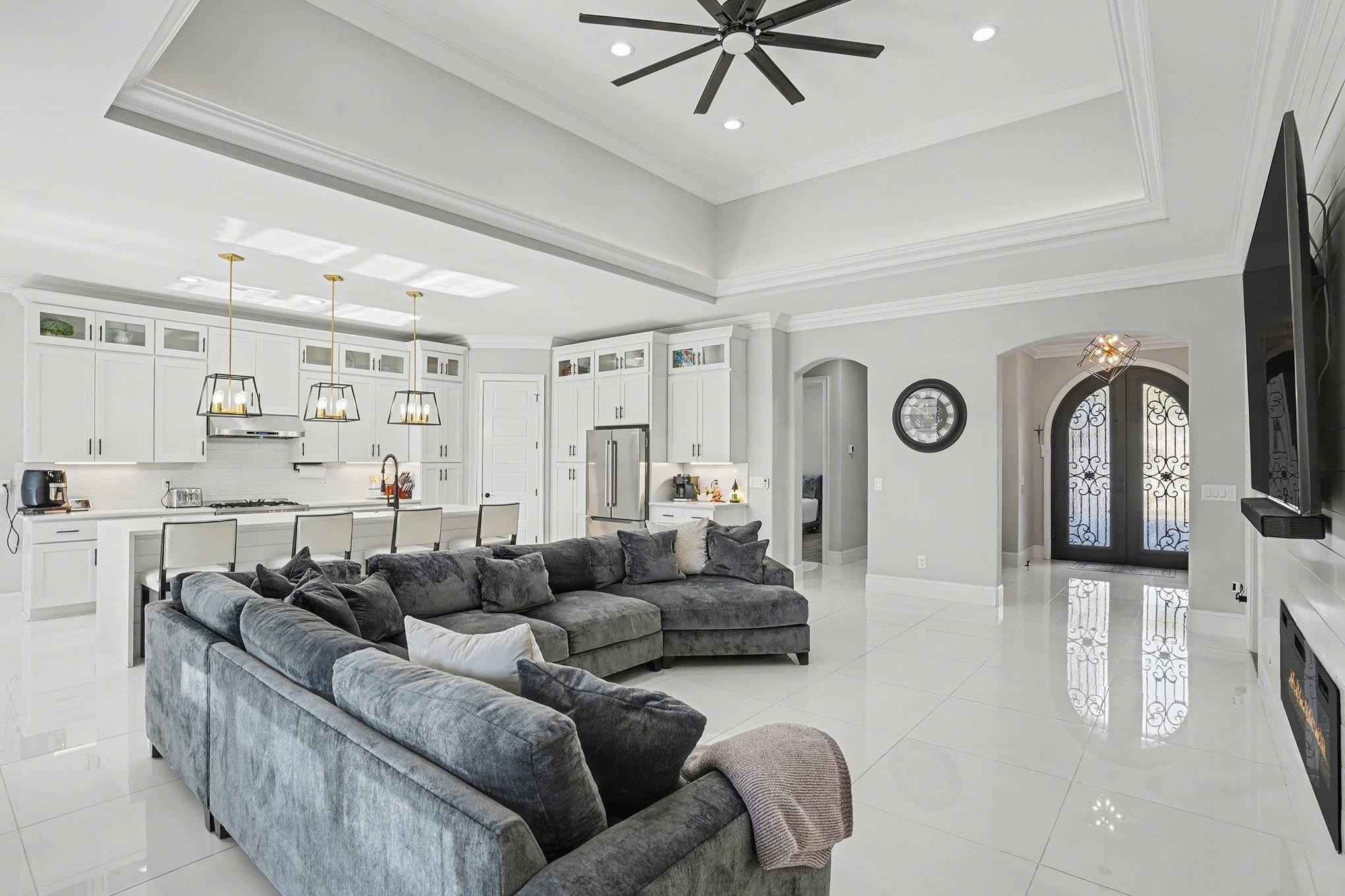 902 Shipmaster Avenue Myrtle Beach, SC 29579 - Photo 4 of 40 Living area featuring a tray ceiling, crown molding, arched walkways, light tile patterned floors, and a ceiling fan