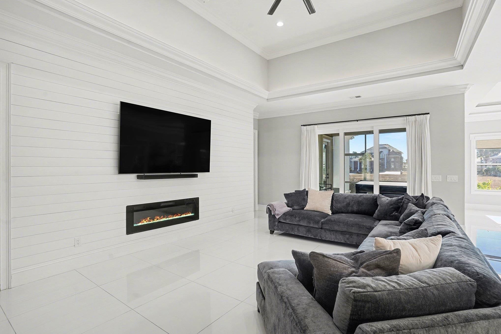 902 Shipmaster Avenue Myrtle Beach, SC 29579 - Photo 5 of 40 Tiled living area with crown molding, a glass covered fireplace, and a ceiling fan