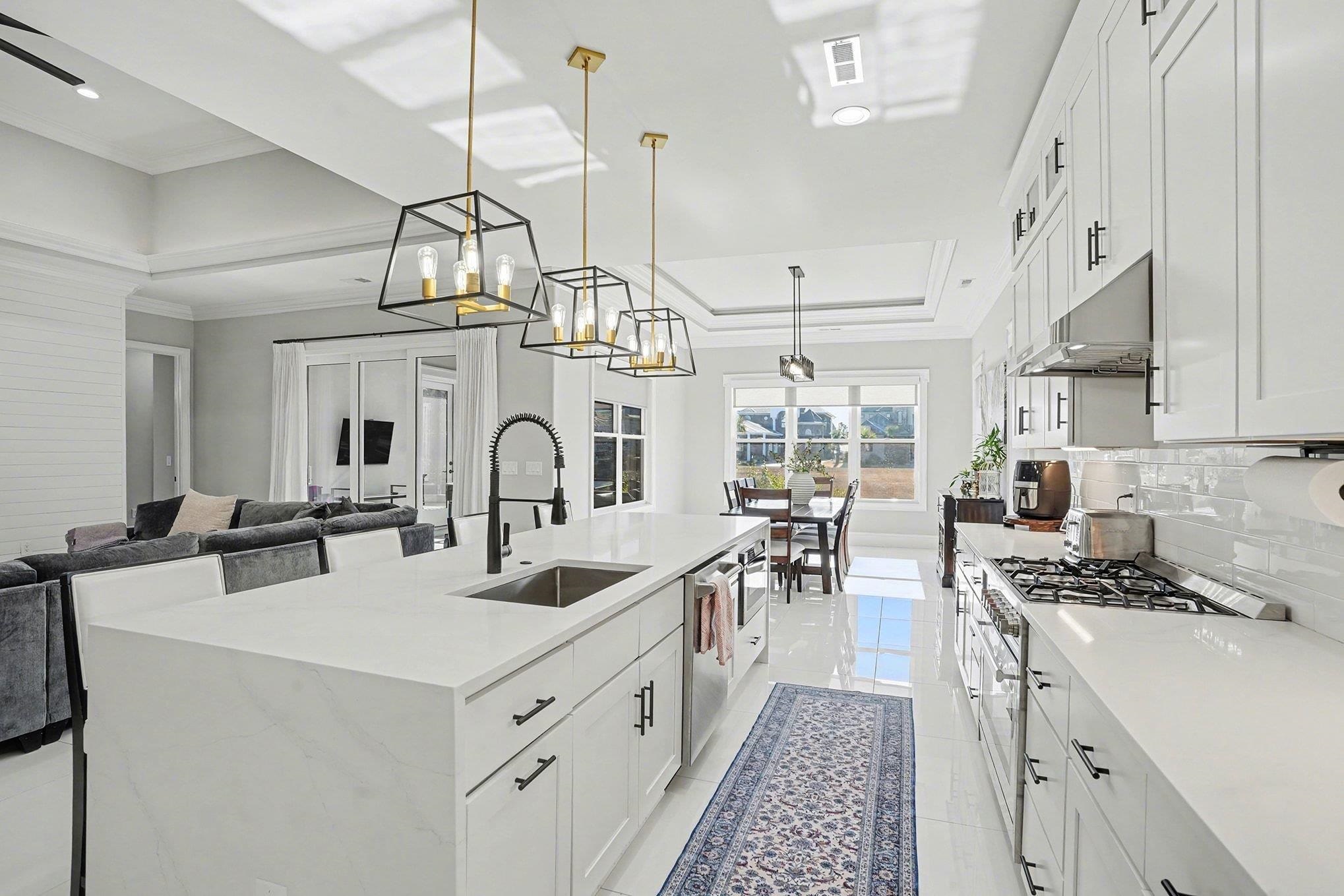 902 Shipmaster Avenue Myrtle Beach, SC 29579 - Photo 39 of 40 Kitchen featuring white cabinetry, pendant lighting, open floor plan, light stone countertops, and crown molding