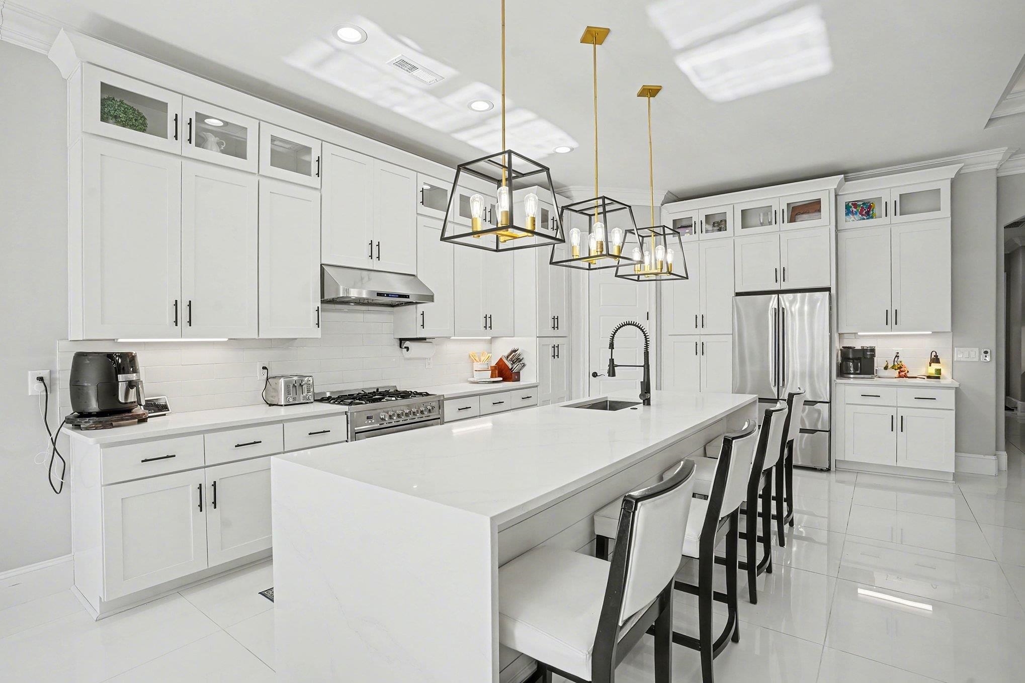 902 Shipmaster Avenue Myrtle Beach, SC 29579 - Photo 9 of 40 Kitchen featuring glass insert cabinets, a kitchen bar, appliances with stainless steel finishes, decorative light fixtures, and light stone counters